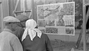 societies under german occupation - Ukrainian citizens standing in front of a German propaganda poster (1941), Bildarchiv Herder-Institut Inv.nr. 146847